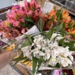 Pick your choice of flowers for the event. We filled the coconut with colorful alstroemeria in white, pink, and orange for an easy tropical look.