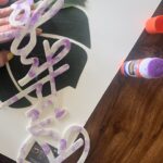 3. GLUE HAPPY BIRTHDAY LETTERING: Apply glue to the back of the Happy Birthday felt sign. Glue onto the large artificial palm leaves.